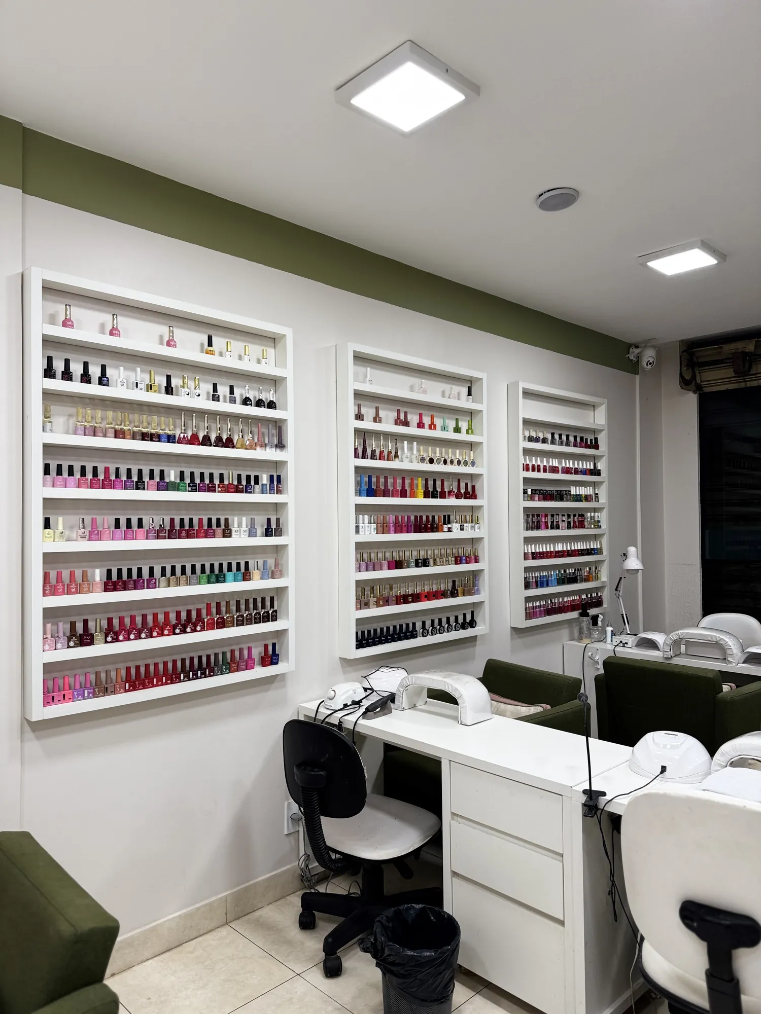 Parede de esmaltes ao lado de uma estação de manicure